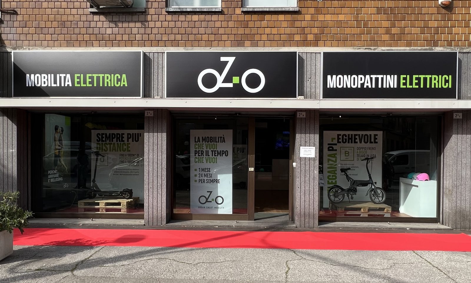 La vetrina di oZ-o Bologna in Via Amedeo Parmeggiani: insegne Mobilit&agrave; elettrica e Monopattini elettrici, eBike e monopattini esposti
